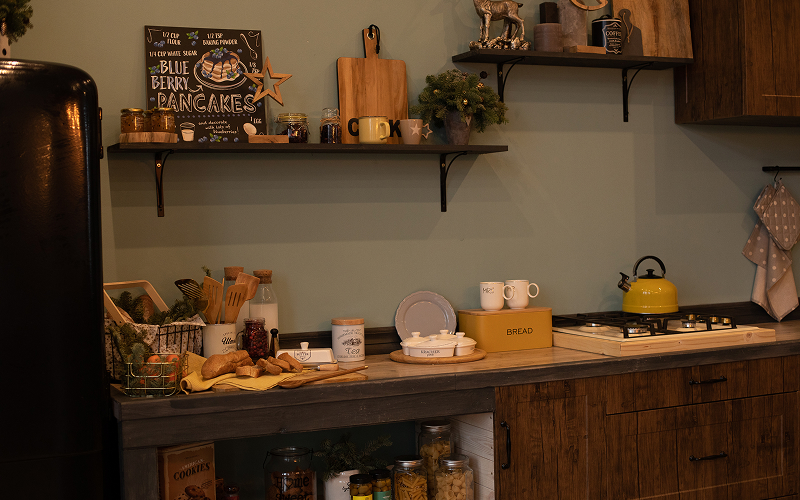 An HDB kitchen with vintage cabinets with soft lighting and open shelving.