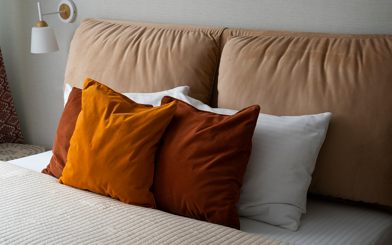 A bed with multiple cushions.