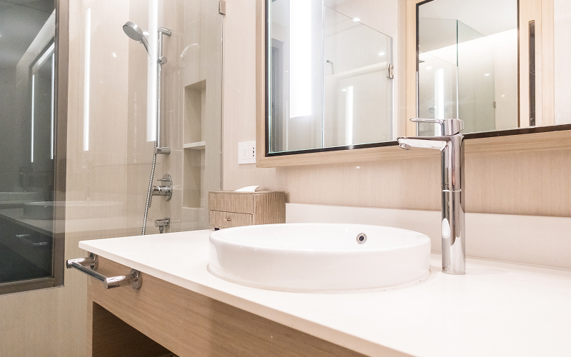 A stock photo of a bathroom with quartz vanity and rainfall shower.