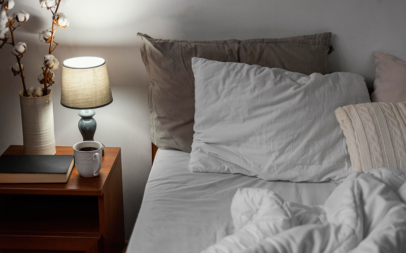 A stock photo of a bedroom with plush bedding and mood lighting.