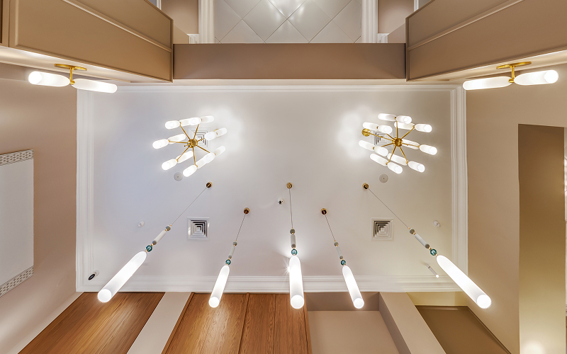 A warm layered-lighting setup with floor lamps, ceiling lights and soft accent glows