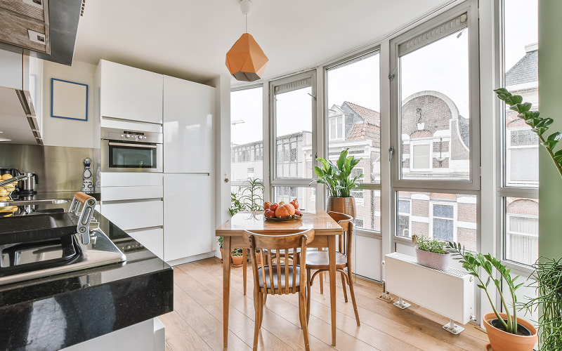 A bright HDB open concept kitchen flowing into a living area
