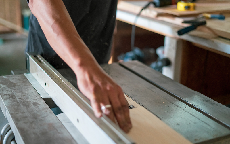 A stock photo of a carpenter working on built-in storage.