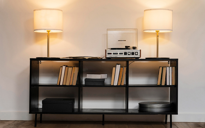 An image of a living room with metal shelving, exposed lighting, and rustic décor.