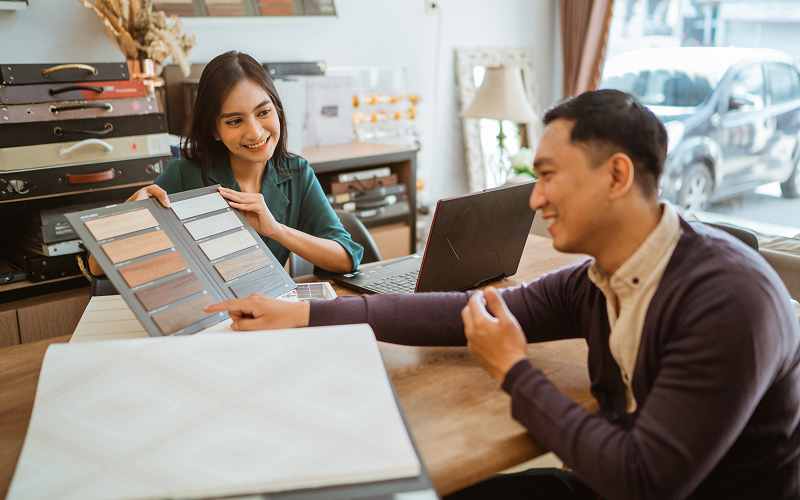 homeowner reviewing kitchen samples and quotes with a consultant in a showroom